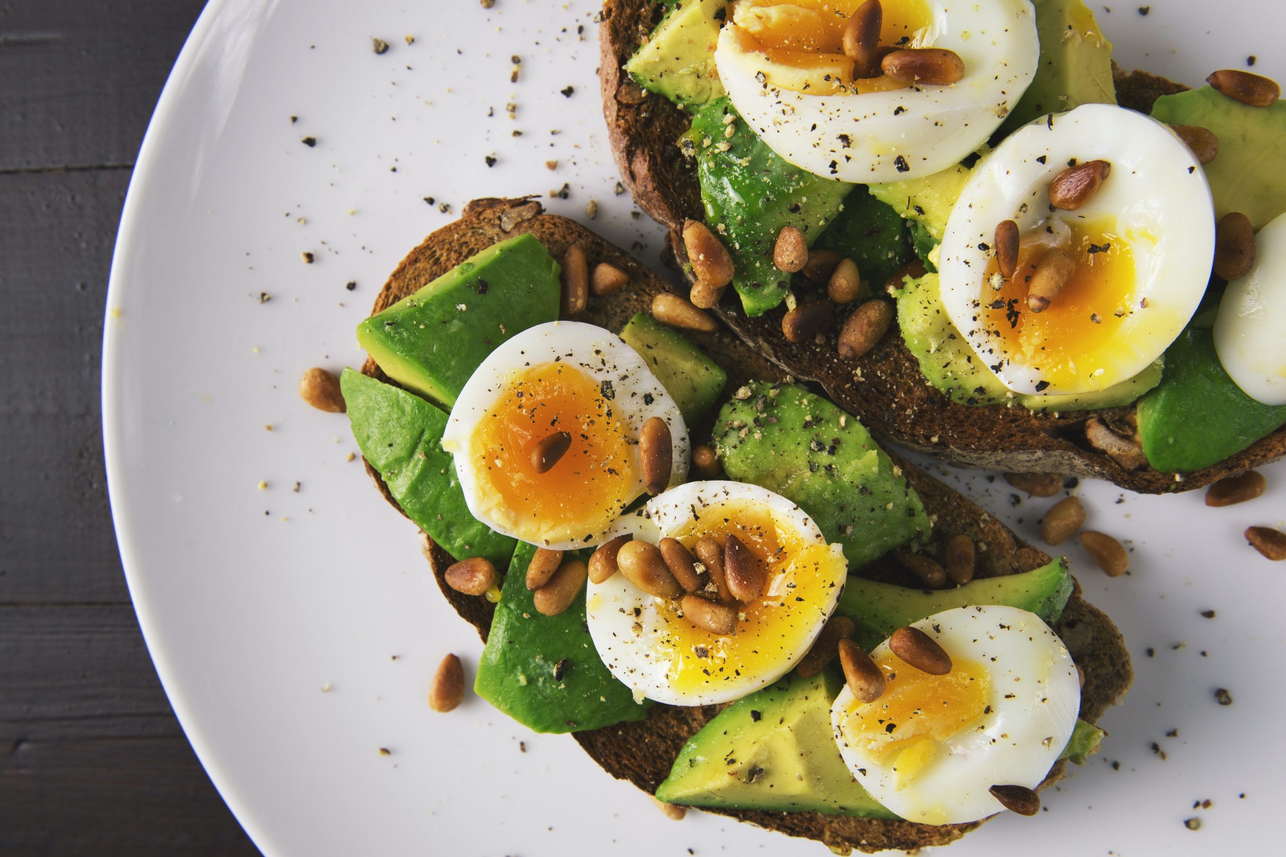 Plate of food with toast, avocado, eggs and nuts
